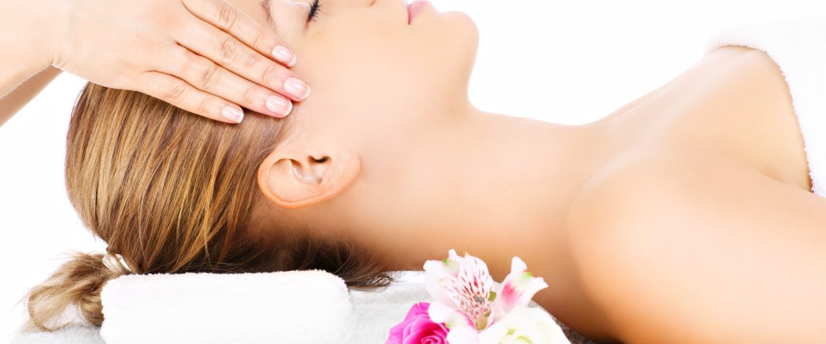 A portrait of a happy woman having a massage over white background